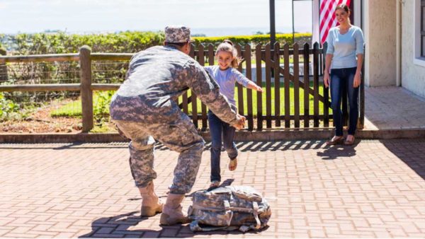 Soldier hugging his daughter at home